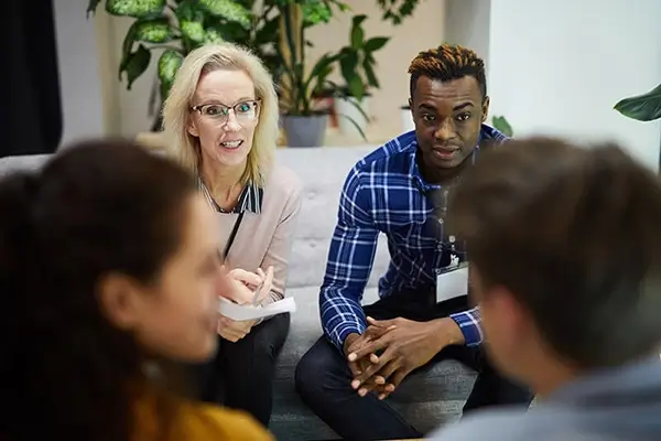 Professional woman and man interacting with a group of people